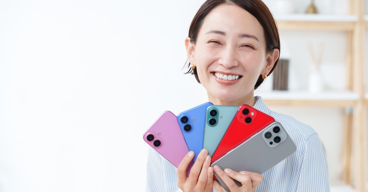 色違いのスマートフォンを複数持って選ぶ女性